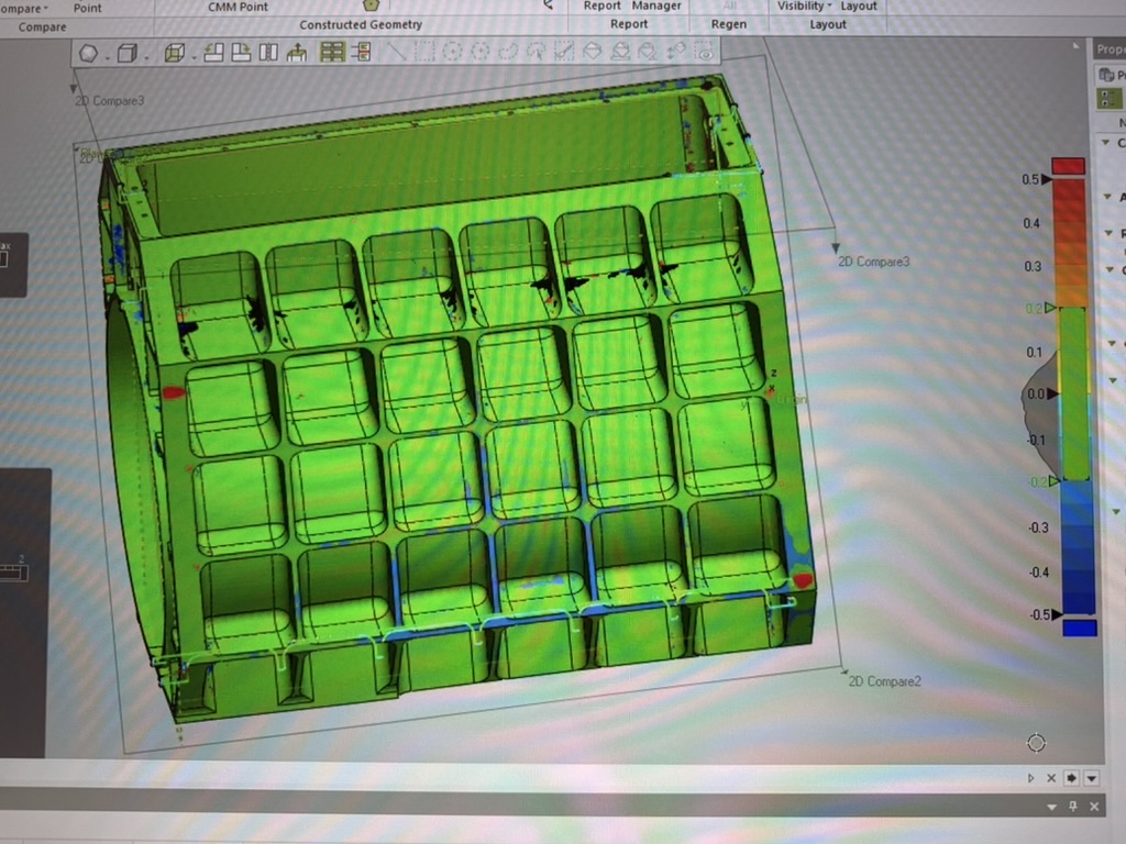 3D scan of the machined housing compared to its CAD model, shown as a color deviation map: mostly green (in tolerance) with a scale from minus 0.5 to plus 0.5.