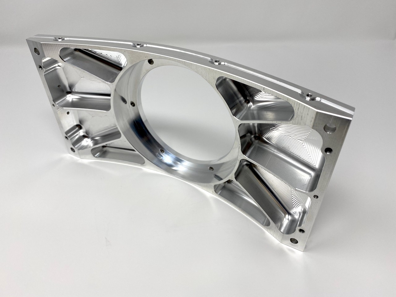 Large machined aluminum structural arm with a precision bore and web pockets.