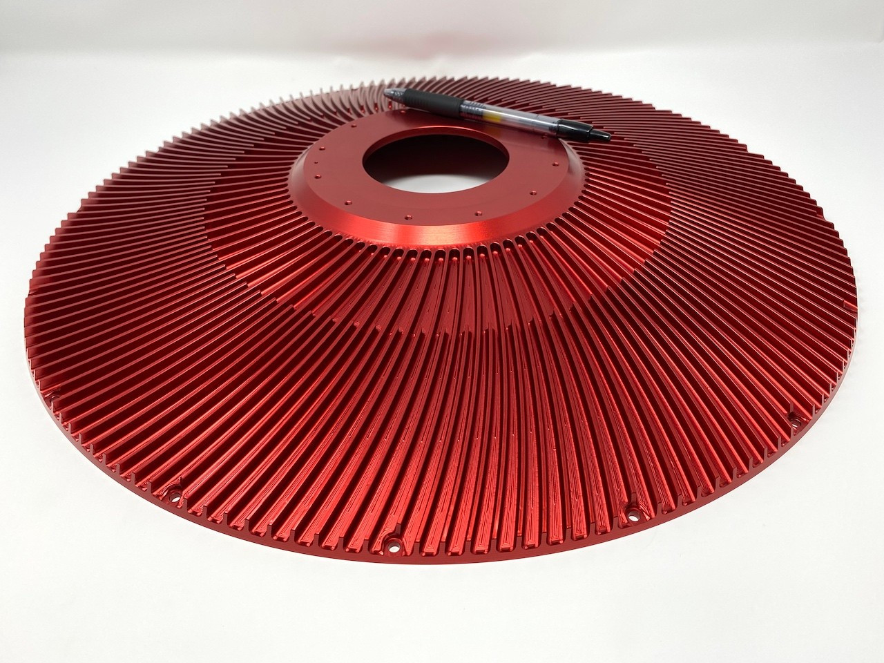 Red anodized finned aluminum rotor with radial fins around a central hub.