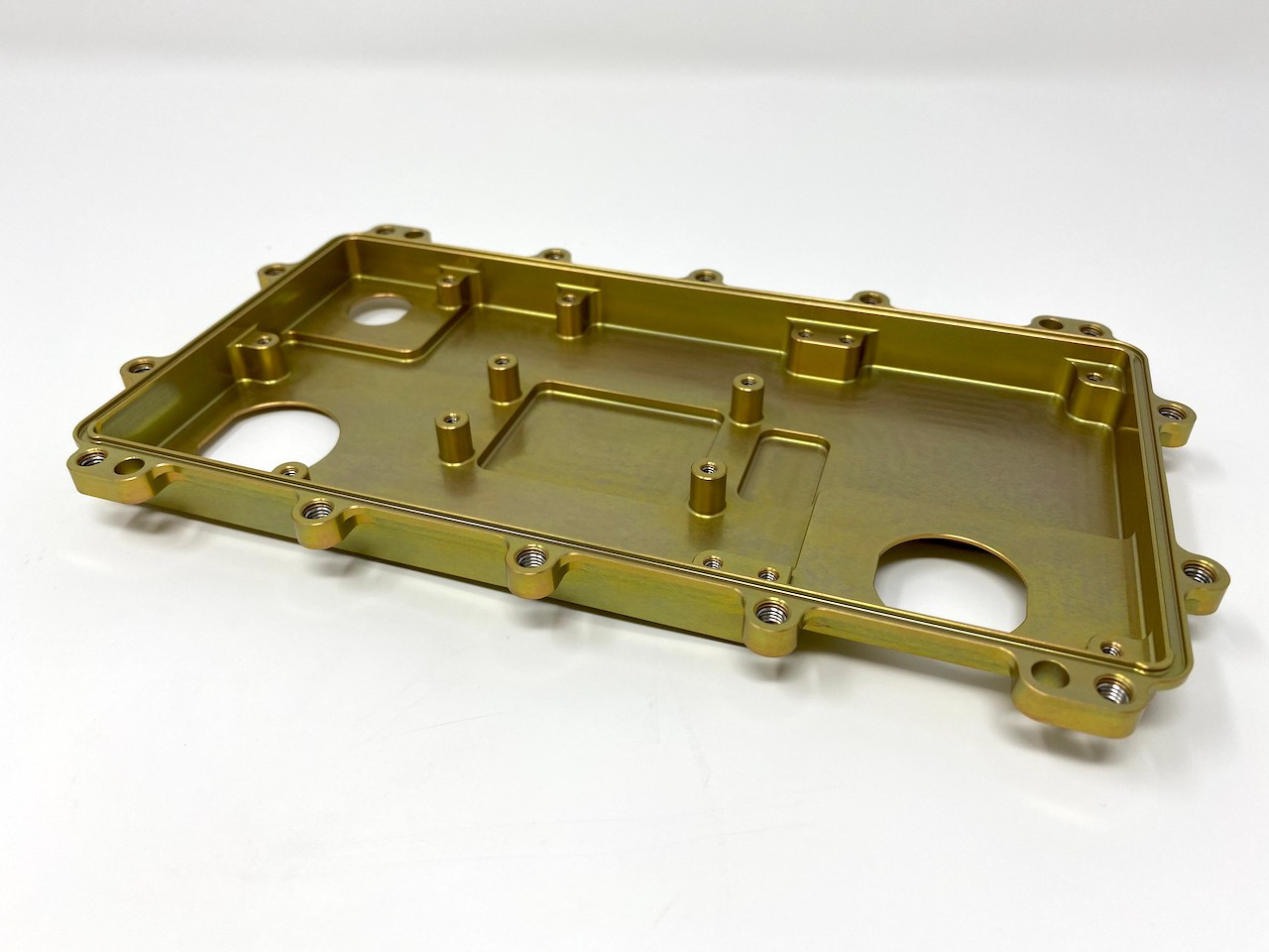 Gold anodized machined plate with integral bosses, pockets and mounting holes.