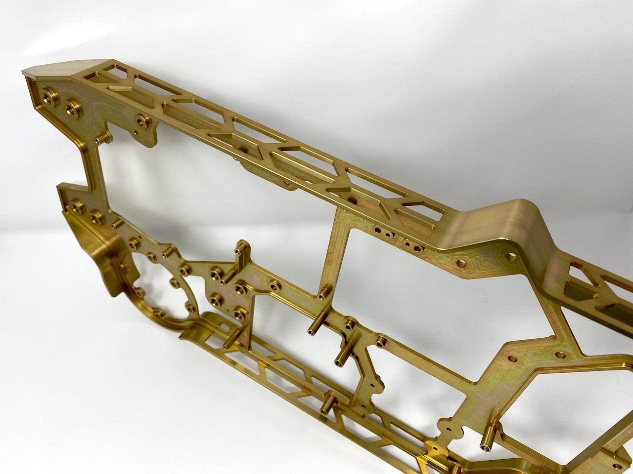 Long gold-anodized aluminum truss frame with hundreds of lightening pockets.